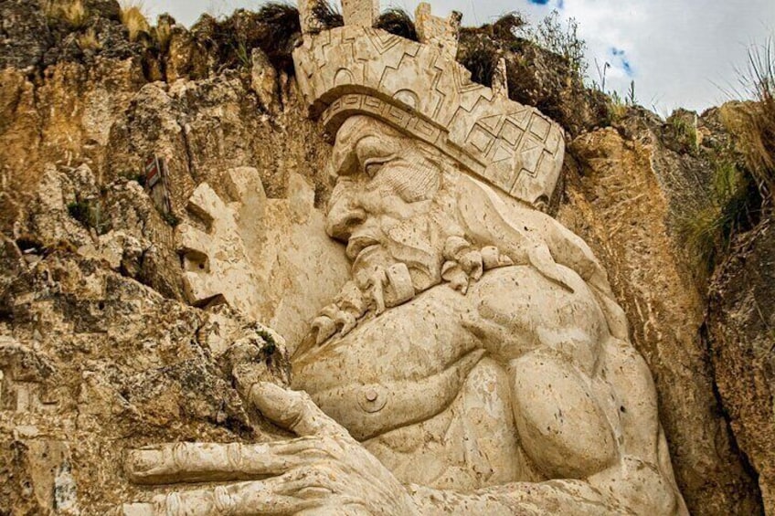 A large stone carving of a figure with a headdress, set against a rocky cliff. 3