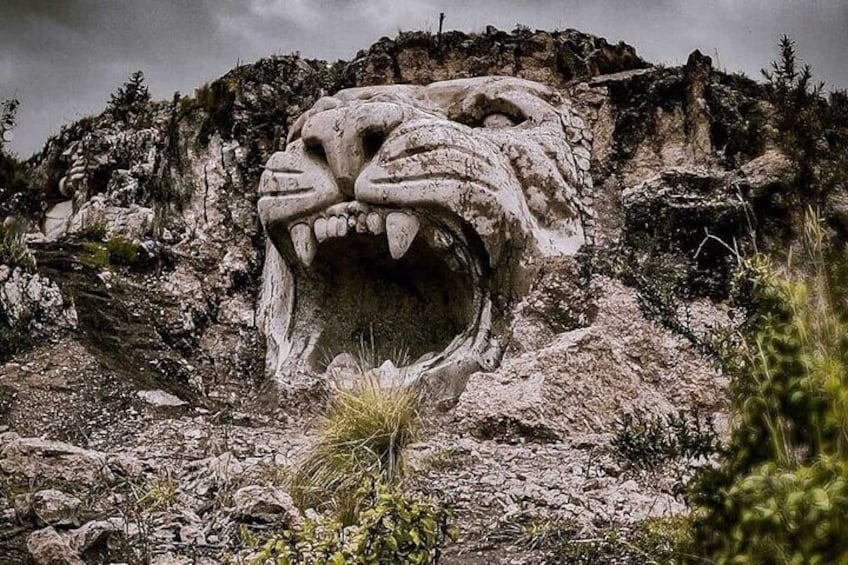 A large stone lion head sculpture in a rocky landscape. 5
