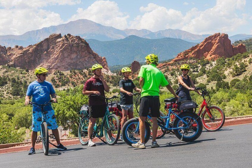 A group of cyclists on a road with a mountainous landscape in the background. 2