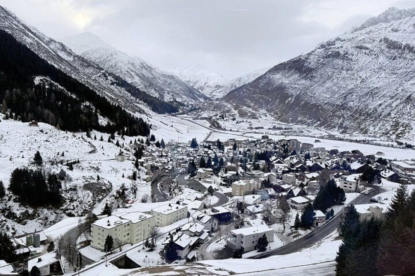 A snow-covered town nestled in a valley with mountains in the background. 5