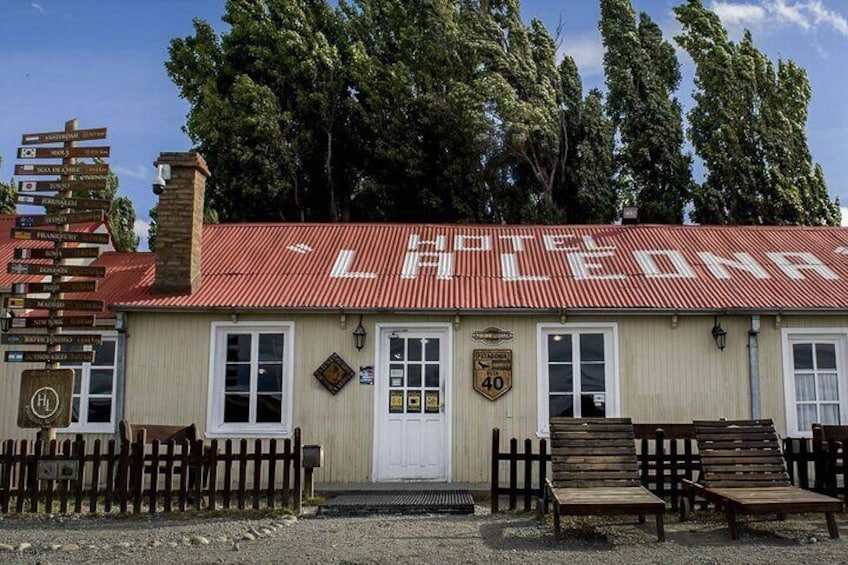 A building with a red roof and a sign that reads 'LAPCHENNA'. There are wooden benches in front of the building. 2