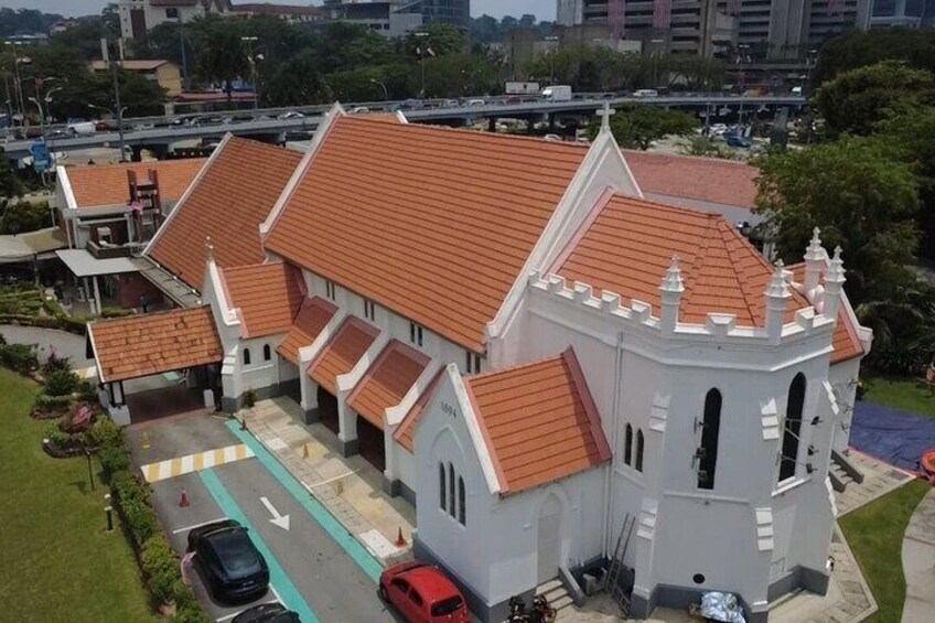 A white church with a red roof, surrounded by a parking lot and greenery. 3