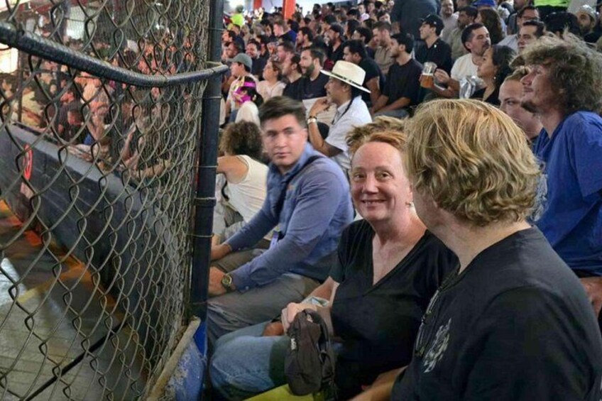 A crowd of people at an outdoor event, some sitting on bleachers. 5