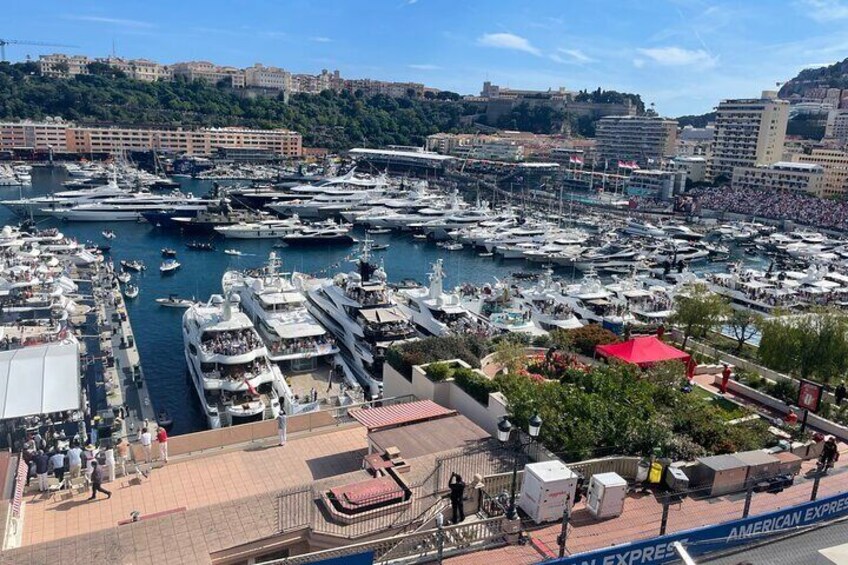 A marina filled with yachts and boats, a waterfront promenade, and buildings in the background. 3