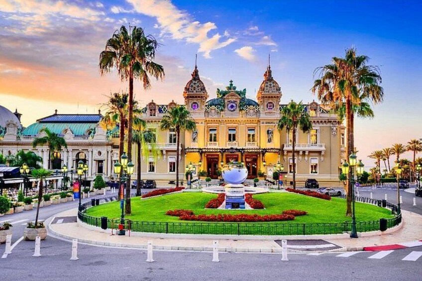 A grand building with domes and towers, surrounded by a well-maintained garden with palm trees. 4