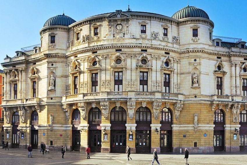 A historic building with ornate architecture, large arched windows, and statues. 3