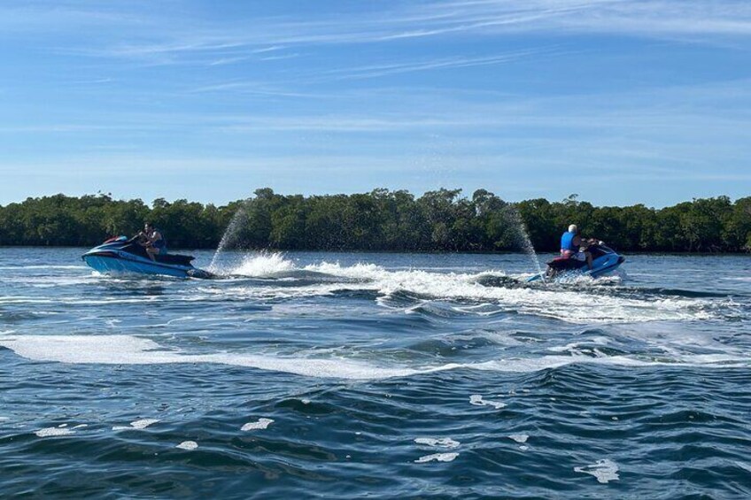 Two jet skis on a lake with a forest in the background. 2