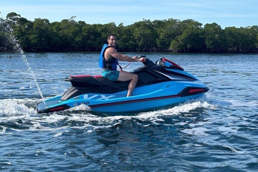 A person riding a blue Yamaha jet ski on water. 5