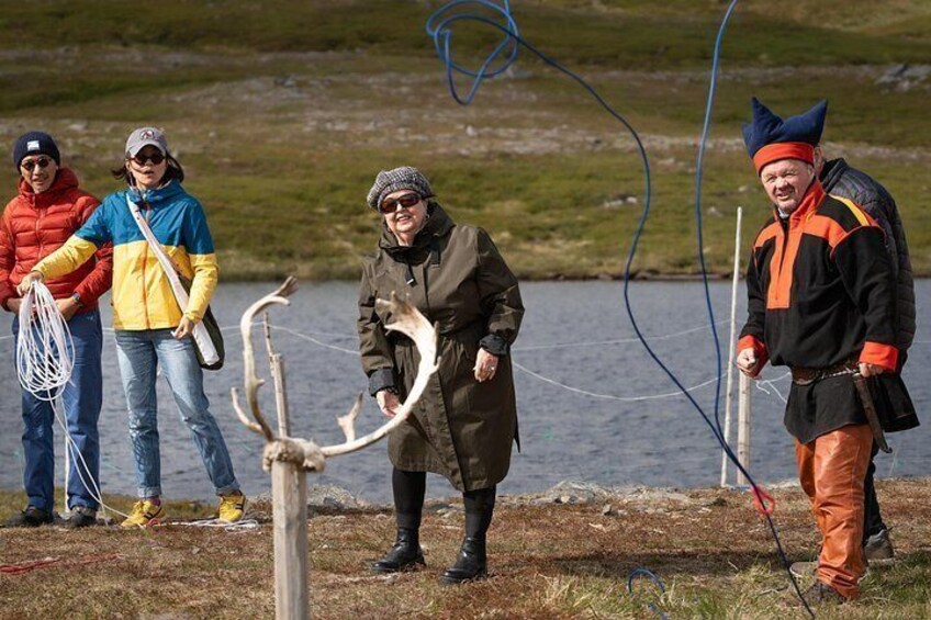 Un grupo de personas junto a un lago, una sosteniendo un gran asta de ciervo. 2