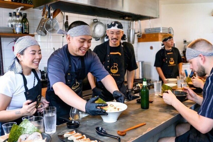 A group of people in a kitchen preparing food. 2