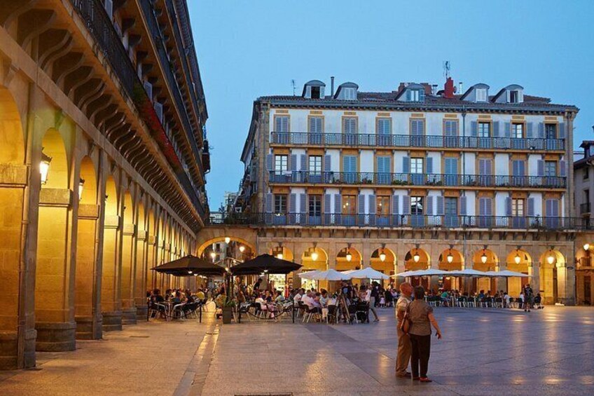 Una plaza histórica con un edificio grande, con balcones y ventanas de arco. 3