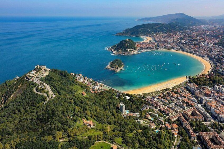 Una ciudad costera con una bahía, una playa y una fortaleza en la cima de una colina. 1