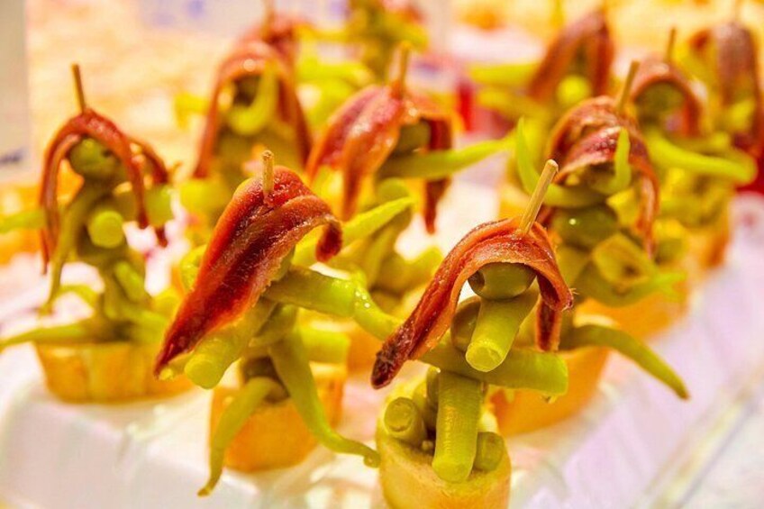 Brochetas con verduras verdes y carne roja, posiblemente tocino, dispuestas sobre un plato. 2