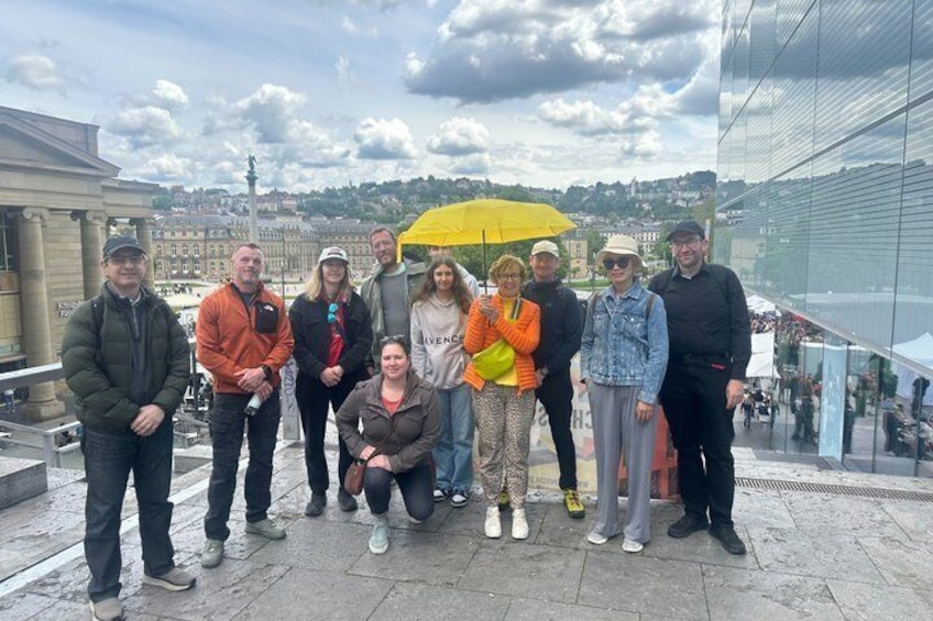 En grupp människor som står på en terrass med en stadsbild i bakgrunden. 1