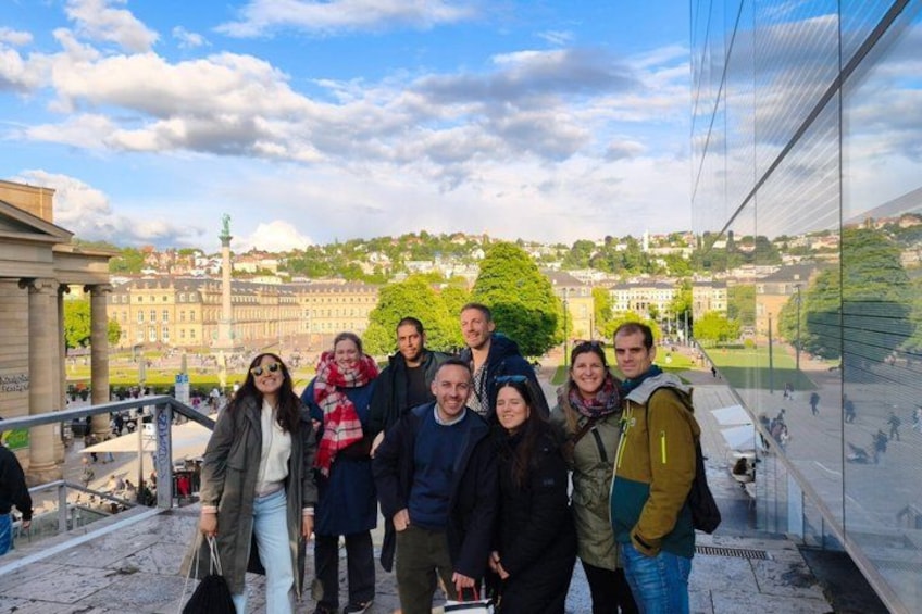 A group of people standing on a bridge with a cityscape in the background. 5