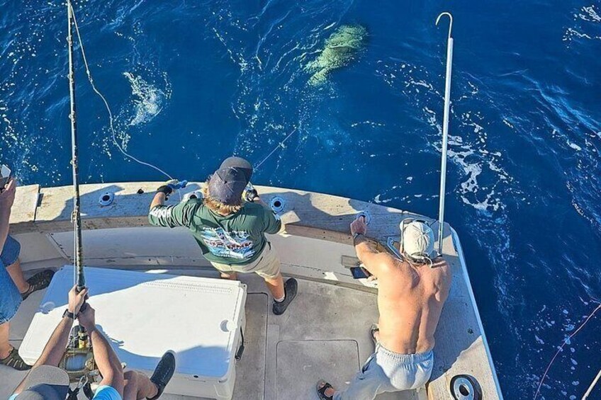 Un bateau avec des personnes qui pêchent, entouré d’une eau océanique bleue. 5