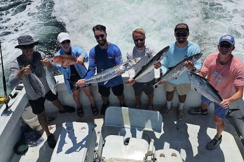 A group of people on a boat holding fish. 3