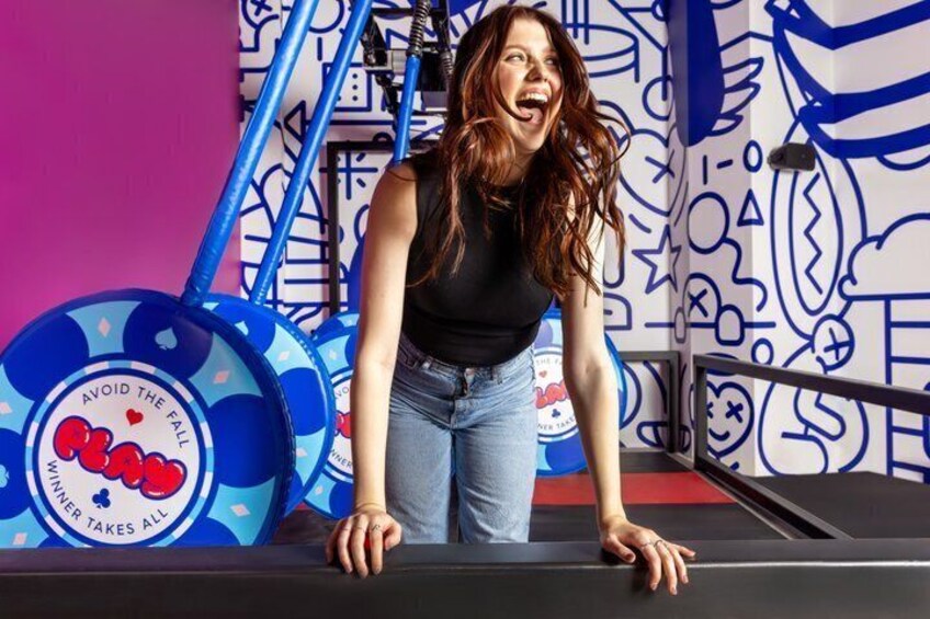 A person leaning on a railing with a blue and white patterned wall in the background. 1