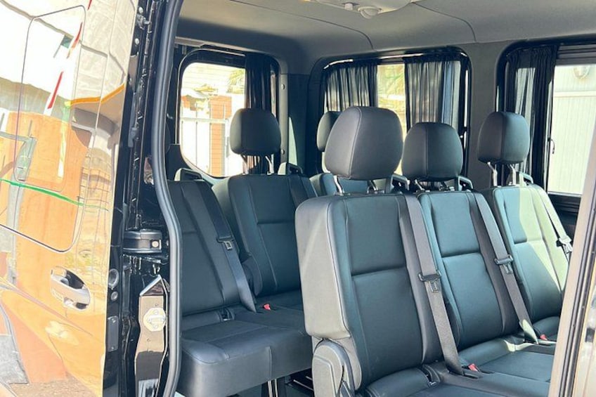 Interior de vehículo con varios asientos y ventanas. 5