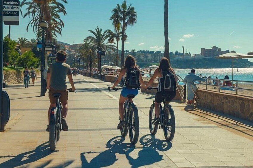 Un paseo marítimo con ciclistas, palmeras y una playa al fondo. 4