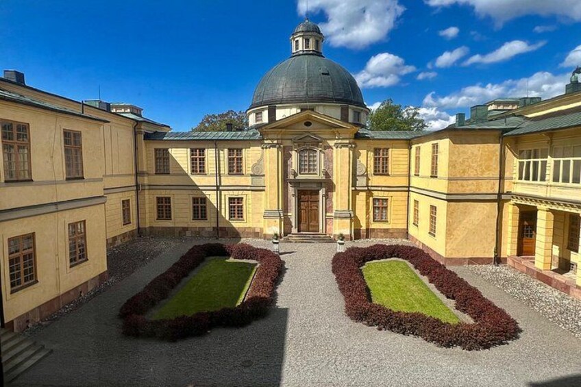 A classical building with a dome and symmetrical garden beds. 5