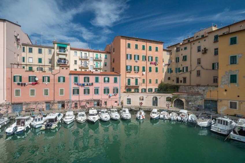 A marina with boats docked, colorful buildings, and a clear sky. 1