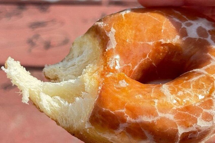 Un donut glaseado a medio comer, con un bocado mordido. 5