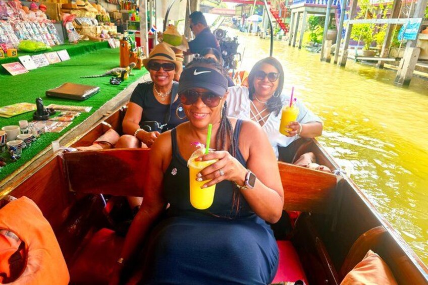 People on a boat with a drink, a green area, and water. 5