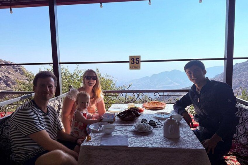 A family dining at a table with a scenic mountain view. 3