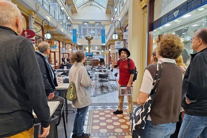 Interior de un centro comercial con gente mirando las tiendas. 4
