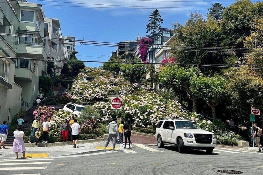 A street scene with a white SUV, pedestrians, and a 'Do Not Enter' sign. 2