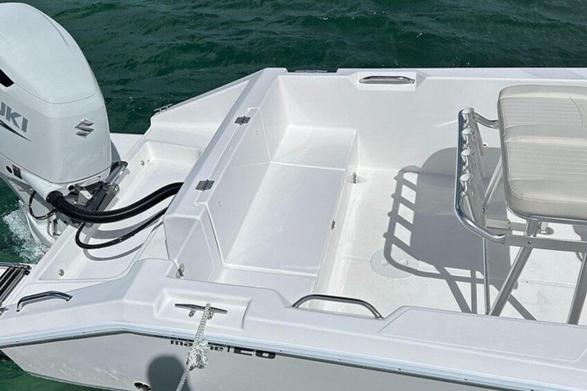 A boat with a Suzuki outboard motor, a white interior, and a metal railing. 3