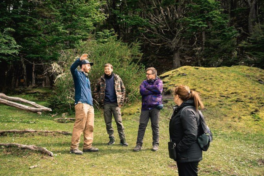 Four people standing outdoors in a grassy area with trees in the background. 2