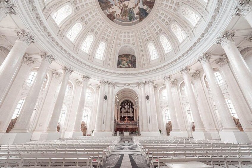 A grand hall with a high ceiling, large columns, and a central altar. 3
