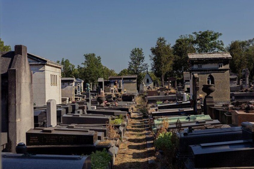 A cemetery with numerous tombstones and headstones, some with arches and others with simple designs. 4