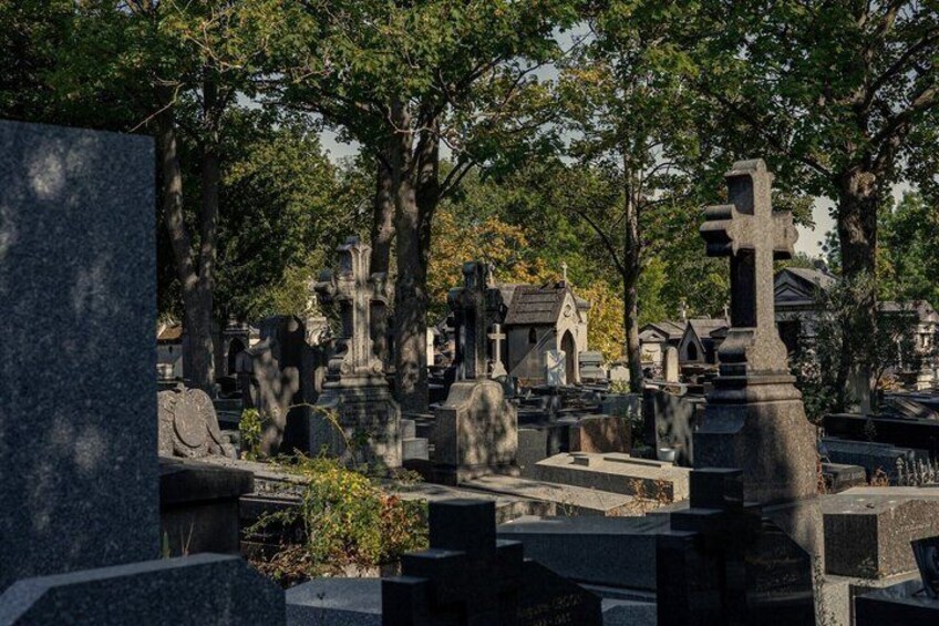 A cemetery with gravestones and crosses, surrounded by trees. 3