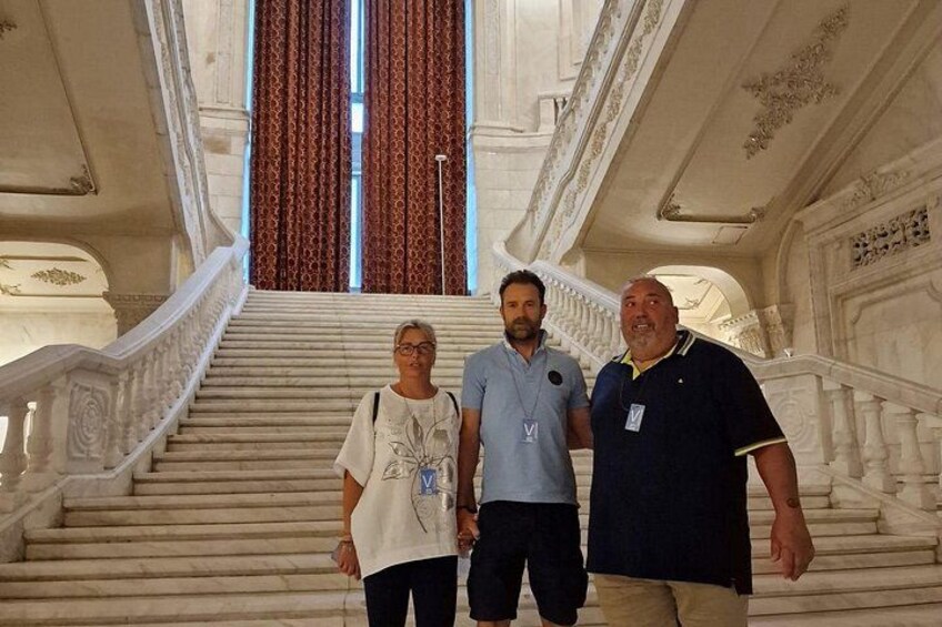 Eine prachtvolle Treppe mit aufwendiger Geländerarbeiten und einem großen Fenster mit Vorhängen. 2