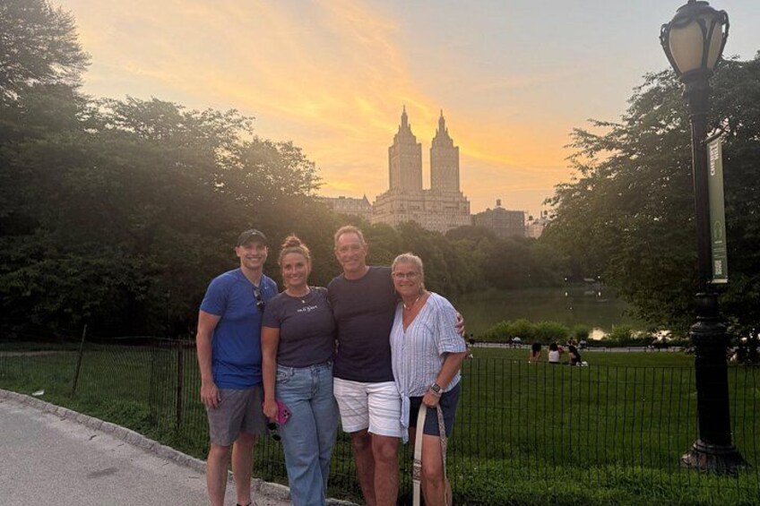 A group of people standing in a park with a city skyline in the background. 2