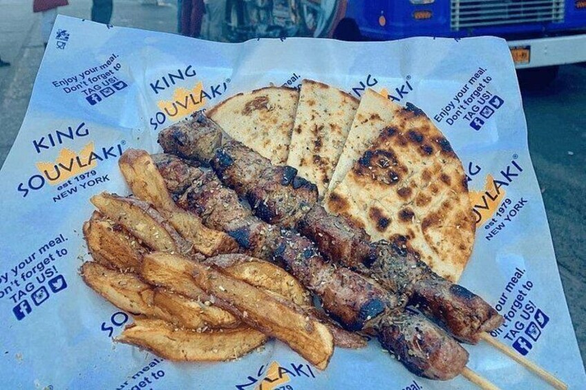 Un puesto de comida con brochetas de carne y pan plano. 2