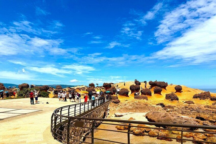 A desert landscape with large rock formations and a metal walkway. 5