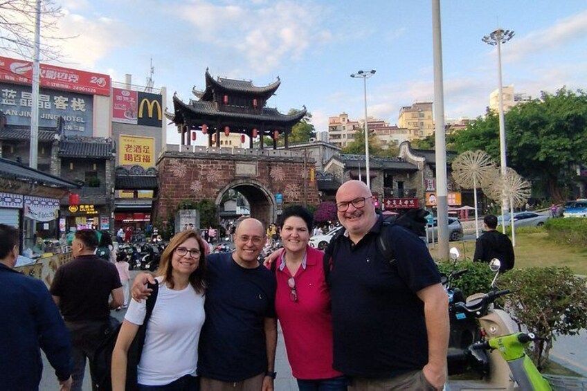 A group of people posing in front of a traditional Chinese gate with a McDonald's sign in the background. 5