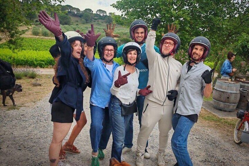 A group of people wearing helmets and casual clothing, standing on a dirt path with greenery in the background. 5