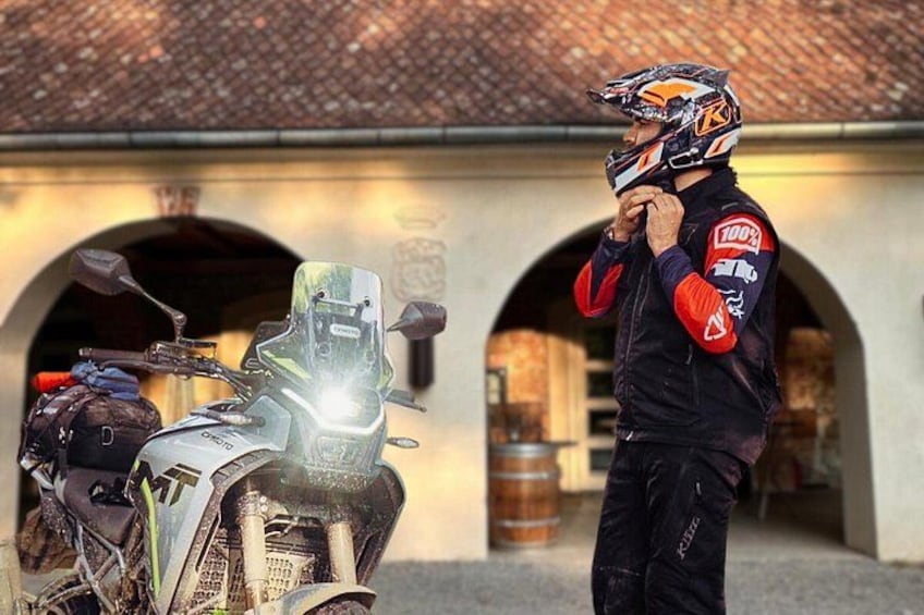 A motorcycle parked in front of a building with arched doorways. 3