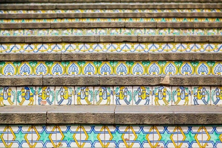 A staircase with colorful tile patterns and stone steps. 5