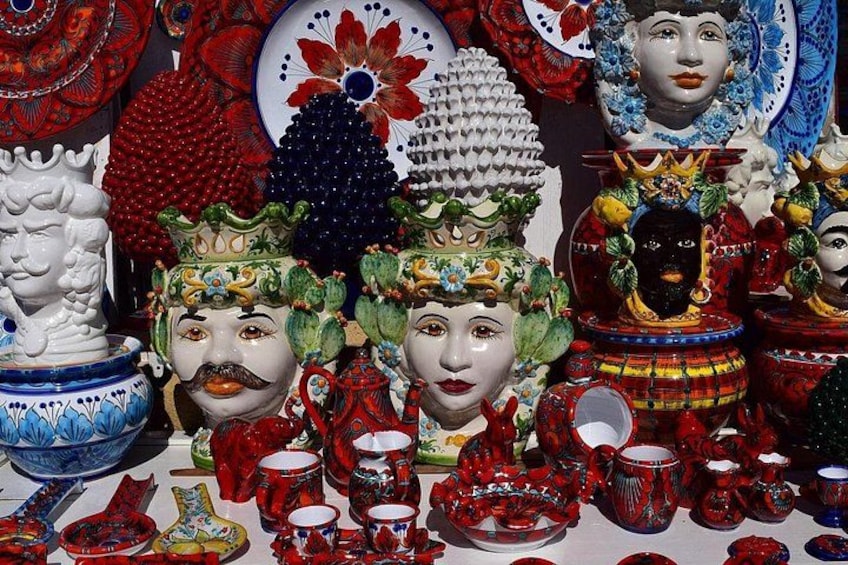 A collection of colorful ceramic items, including bowls, plates, and cups, with intricate designs and vibrant colors. 1