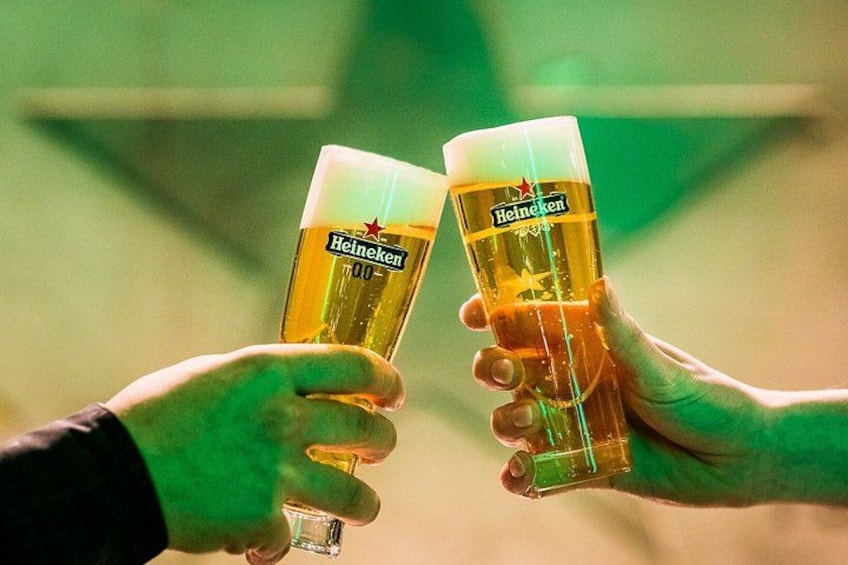 Two hands holding Heineken glasses with a greenish background. 2