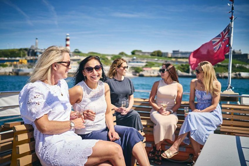A group of people on a boat with a lighthouse in the background. 3