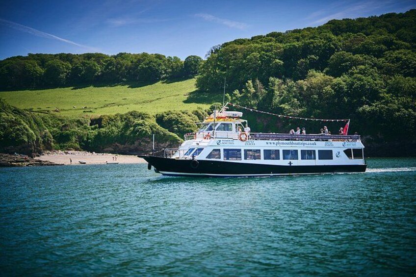 A boat on a body of water with a green landscape in the background. 3