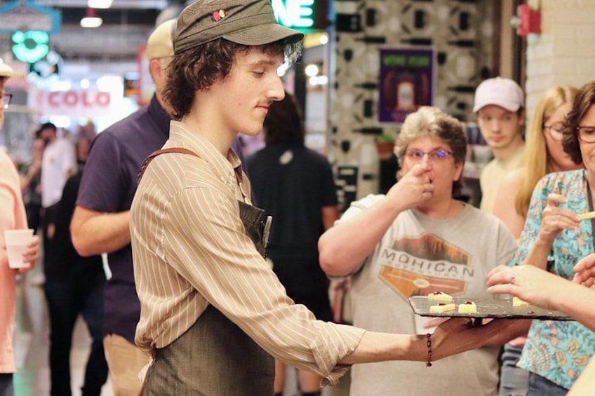 A person serving food to a crowd at an indoor event. 2