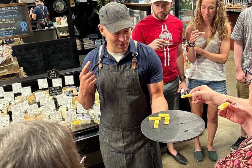A person holding a tray with yellow letters, standing in a store with various items on shelves. 4